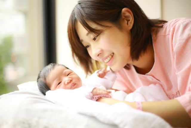 赤ちゃんと微笑むママ